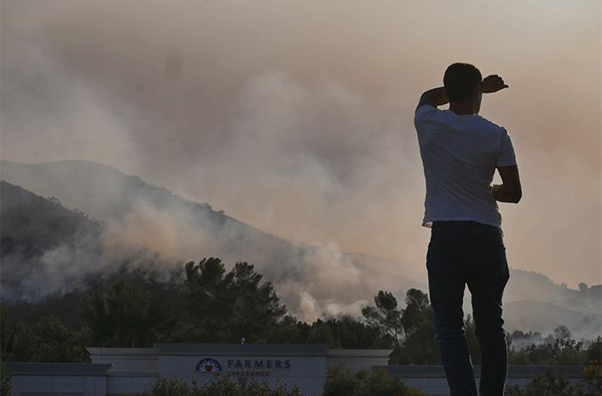 man looking out at wildfire smoke